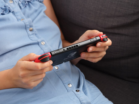 Tambov, Russian Federation - July 26, 2021 A woman playing on a Nintendo Switch video game console.のeditorial素材