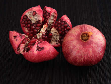 Fresh organic pomegranate slices. Low key. Close up.