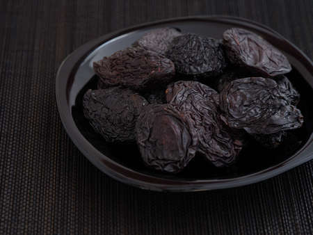Prunes in a bowl. low key. close up.の写真素材
