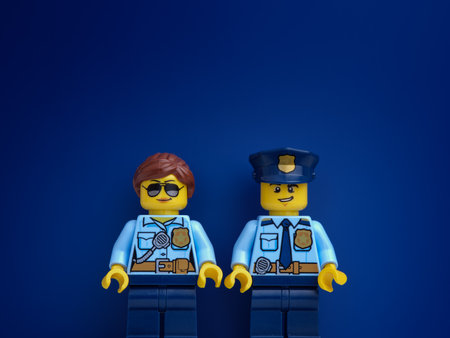 Tambov, Russian Federation - March 11, 2022 Two Lego police officer minifigures standing against a dark blue background. close up.のeditorial素材