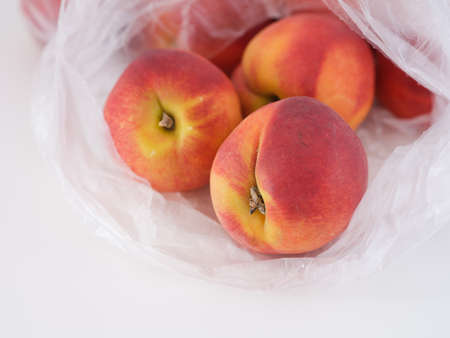 Freshly harvested peaches in a plastic bag. close up.