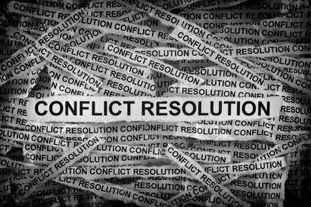 Strips of newspaper with the words Conflict Resolution typed on them. Black and white. Close up.の写真素材