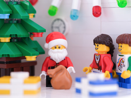Tambov, Russian Federation - November 15, 2022 Lego Santa Claus and children minifigures standing near a Christmas tree with gifts around it.のeditorial素材