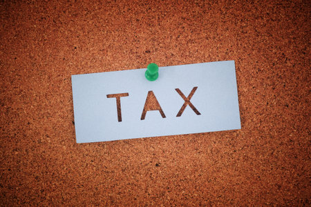 The word TAX pinned to a cork board. Close up.の写真素材