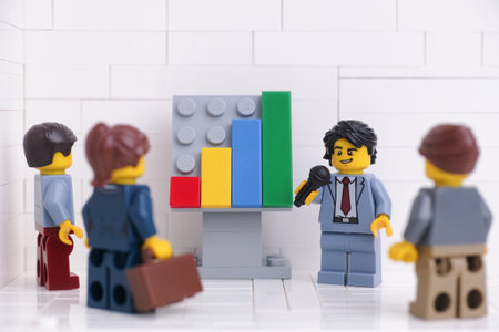 Tambov, Russian Federation - January 18, 2023 Lego businessperson minifigures having a meeting and discussing graphs that show the results of their successful teamwork.のeditorial素材