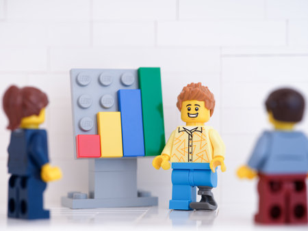 Tambov, Russian Federation - January 24, 2023 Lego businessperson minifigures having a meeting and discussing graphs that show the results of their successful teamwork.のeditorial素材