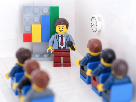 Tambov, Russian Federation - February 18, 2023 Lego businesspeople minifigures having a meeting and discussing graphs showing the results of their successful teamwork.のeditorial素材