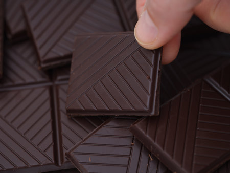 A woman taking a piece of organic dark chocolate. Close up.の写真素材