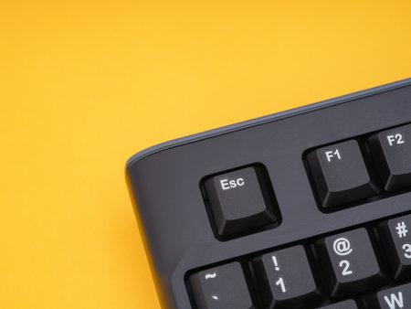 A black computer keyboard on a yellow background. Close up.の写真素材