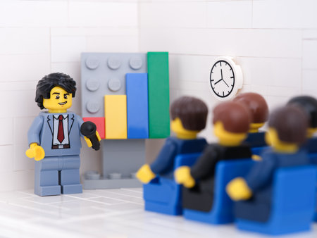 Tambov, Russian Federation - February 18, 2023 Lego businesspeople minifigures having a meeting and discussing graphs showing the results of their successful teamwork.のeditorial素材