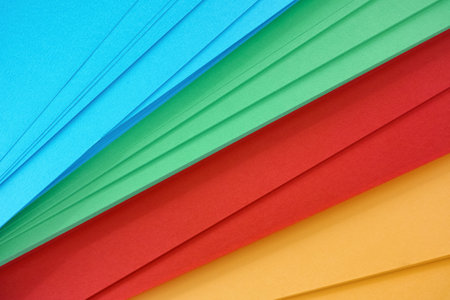 A background of yellow, red, green and blue paper. Close up.の写真素材