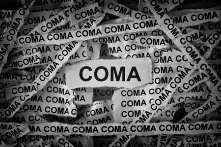Strips of newspaper with the word Coma typed on them. Black and white. Close up.の写真素材