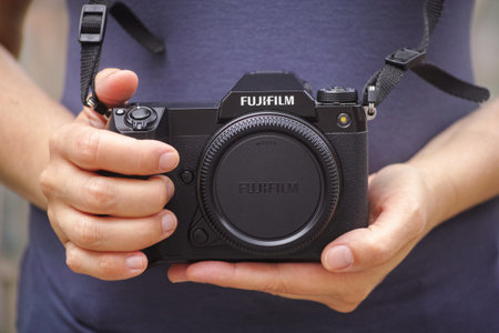 Tambov, Russian Federation - May 21, 2023 A woman holding a Fujifilm GFX 100S medium format camera body in her hands. Close up.のeditorial素材