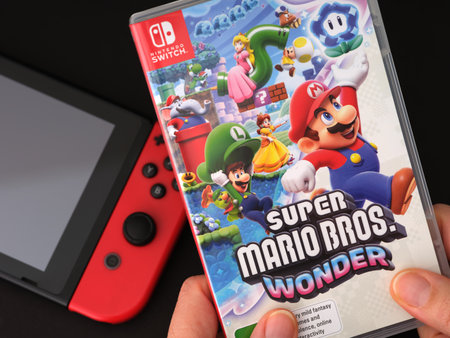 Tambov, Russian Federation - November 28, 2023 A woman holding a Super Mario Bros. Wonder game case in her hands.のeditorial素材