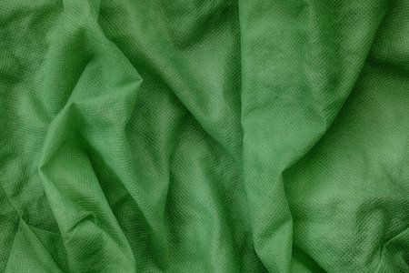 A green nonwoven fabric background. Close up.