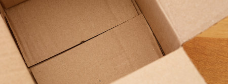 Empty cardboard box a wooden floor. Close up.