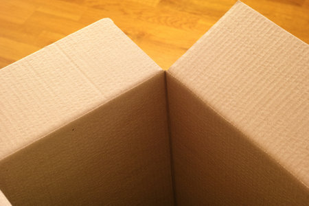 Empty cardboard box on a wooden floor. Close up.