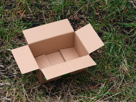 An empty cardboard box lying on grass outside. Close up.の写真素材