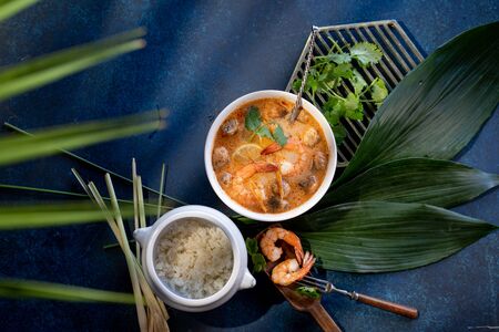 Tom yam with shrimps and rice on blue backgroundの写真素材