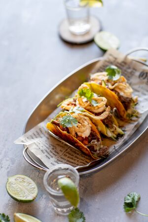 Mexican meat tacos with tequila shots on stone backgroundの写真素材