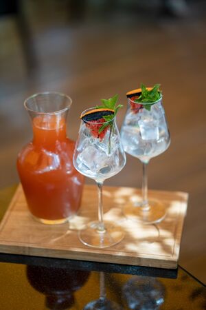 Grapefruit lemonade with glasses on wooden board