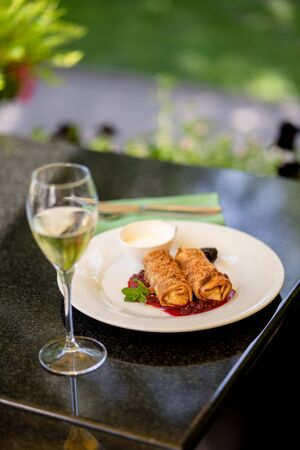 Thin pancakes with jam and glass of wine at summer terrace bokehの写真素材