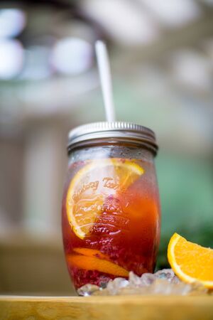 Summer lemonade on table with slice orange and ice on summer cafe bokehの写真素材