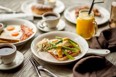 Breakfast with coffee toast with egg juice daylight cafe restaurant towel american wooden table bokehの写真素材