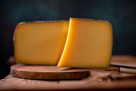 Hard cheese parmesan on wooden board on sunlight table traditional table texture side viewの写真素材