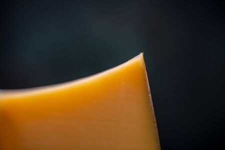 Hard cheese parmesan on wooden board on sunlight table traditional table texture side viewの写真素材