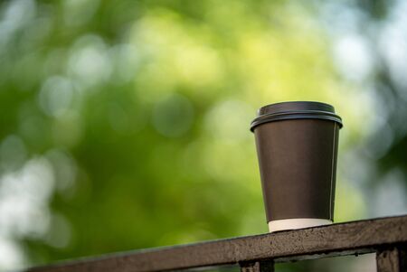 Cup of coffee on the city streets leaves leaf sunlight sunshine town nature side view