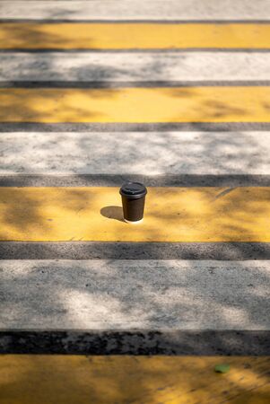 coffee cup on the street road markup city town leaf shadows sunlight sunset side view