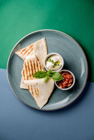Chiken quesadilla topping sauce cream salsa tomato mint dish grill grilled top viewの写真素材