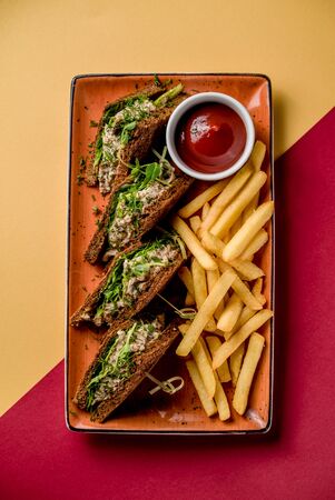 Sandwich with tuna salad vegetables french fries potato sauce fish bread top viewの写真素材