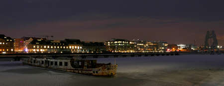 Berlin, Germany, February 16, 2021, night scene with frozen river Spree at Osthafen in Berlin Treptow with shipwreckのeditorial素材