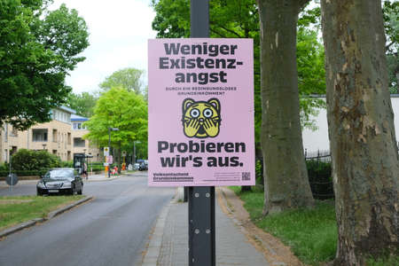 Berlin, Germany, May 14, 2022, poster for the "Referendum Basic Income" in Alt Stralau "Less existential angst" through an unconditional basic income? "Let's try it out".(Focus on the poster)のeditorial素材