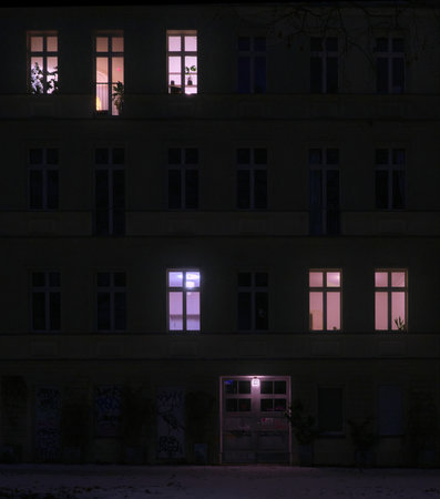Berlin, Germany, January 12, 2026, nighttime facade of a typical Berlin apartment building with partially lit windowsのeditorial素材