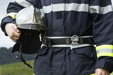Fireman holding his helmet. Close up shot.の写真素材