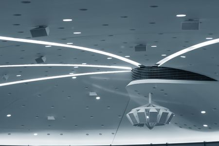 White conference room ceiling with speakers. Blue taint.