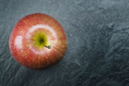 A red delicious apple on grey background.