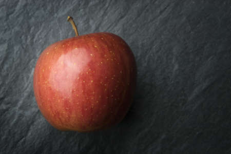A red delicious apple on grey background.