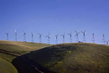 Wind turbines up on the hills in the late afternoon.の写真素材