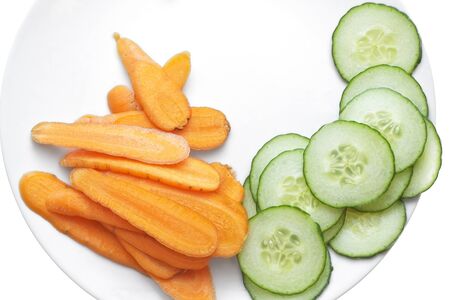 Fresh carrot and cucumber slices , arranged  in  a white plate.の写真素材