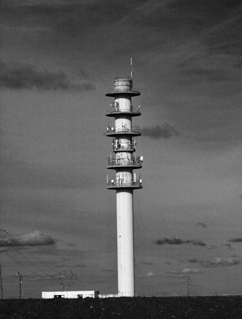 Telecommunications tower with relay antennas, black and white parablesの写真素材
