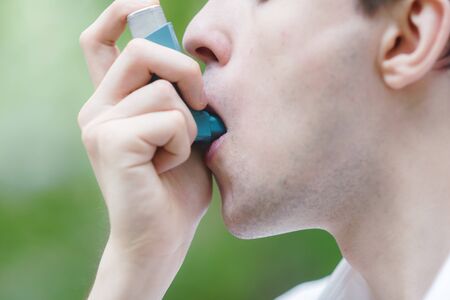 Young man is using a asthma inhalerの素材 [FY310132172124]