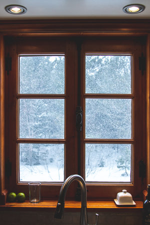 Vintage wooden window with a view of the snowfall and forest.の写真素材
