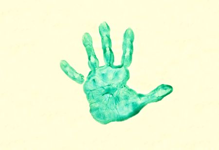 Actual preschoolers hand print on yellowish paperの写真素材