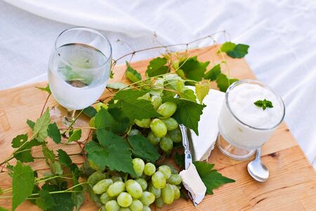 Fresh grapes and vanilla yogurt with mint served outdoors. の写真素材