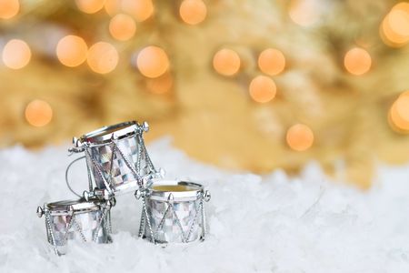Three Christmas drums lying in the snow with bright bokeh background and room for copy space. の写真素材