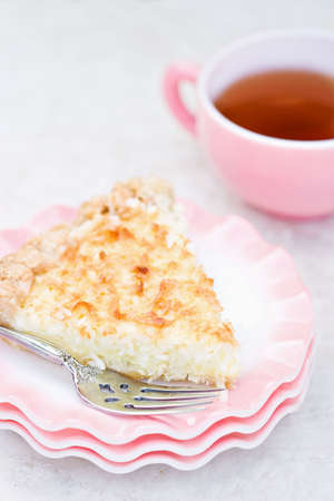 Macro of a slice of coconut pie with tea in background. Shallow DOF.の写真素材